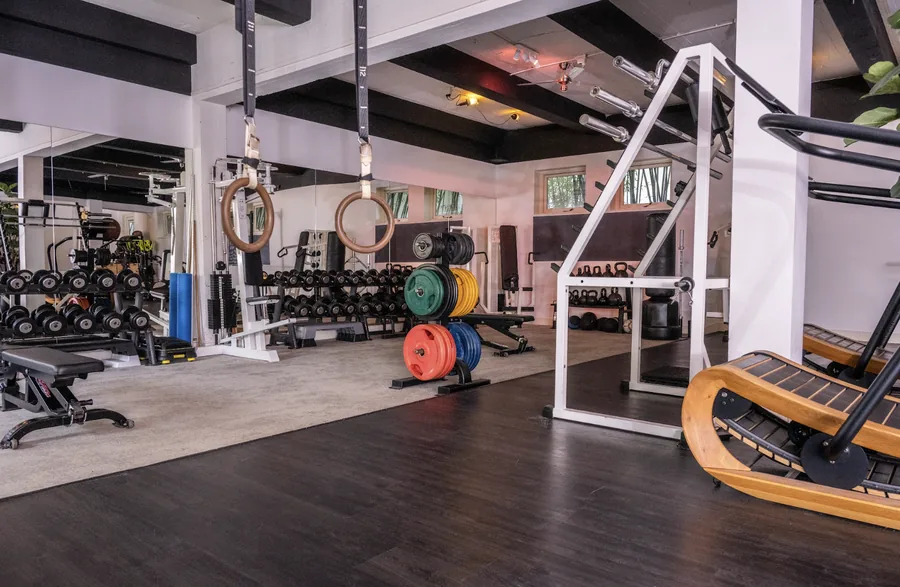 De zaal met ringen, halters en de houten loopband